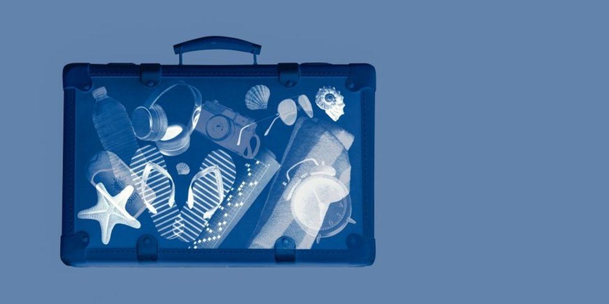 Röntgenfelvétel egy bőröndről, benne utazási kiegészítőkkel, nyári vakáció koncepcióval, másol hely